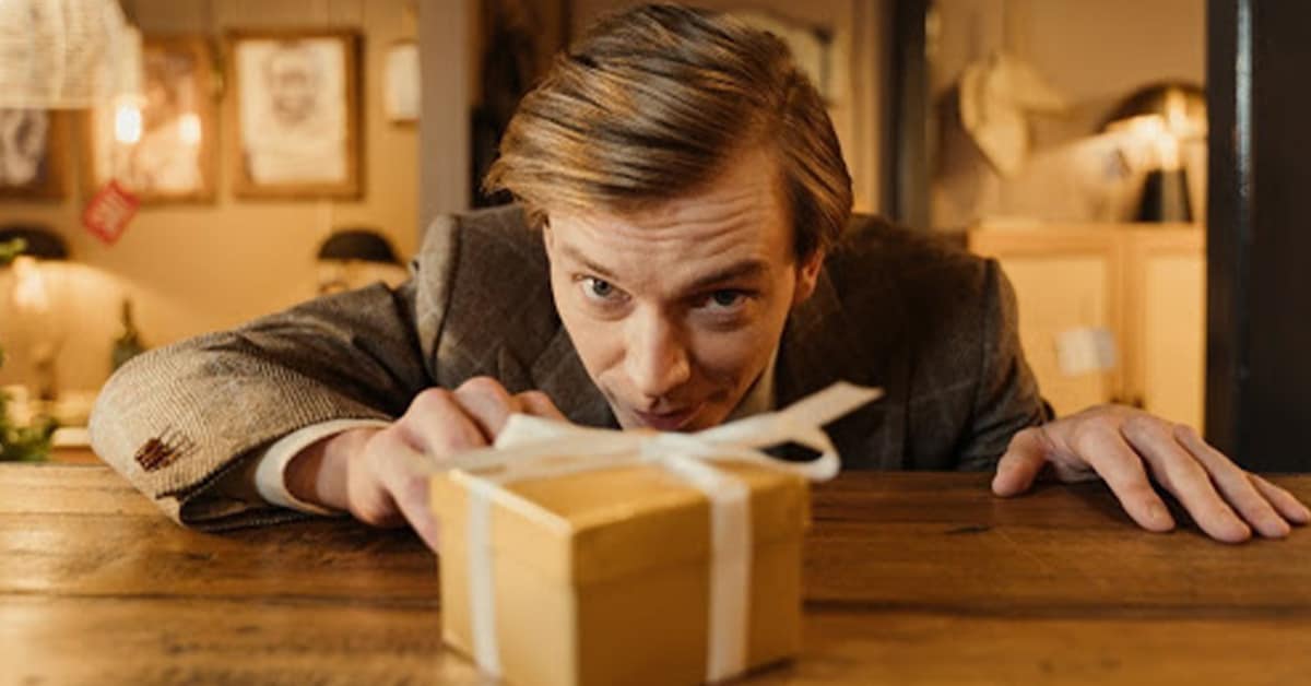 Man reaching towards small gift box.